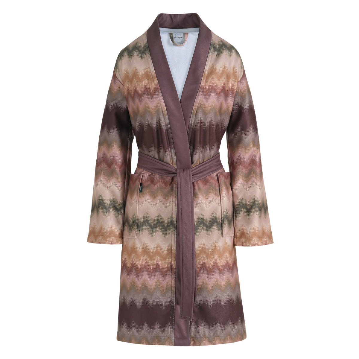 Ava badjas multi is een lange badjas met een zigzagpatroon in verschillende tinten paars, roze, terracotta en groen en accenten in aubergine paars. De badjas heeft grote insteekzakken, brede revers en wordt gesloten met een ceintuur. De Ava badjas multi van Vandyck heeft door de ardetinten en het fijne patroon een luxe uitstraling.