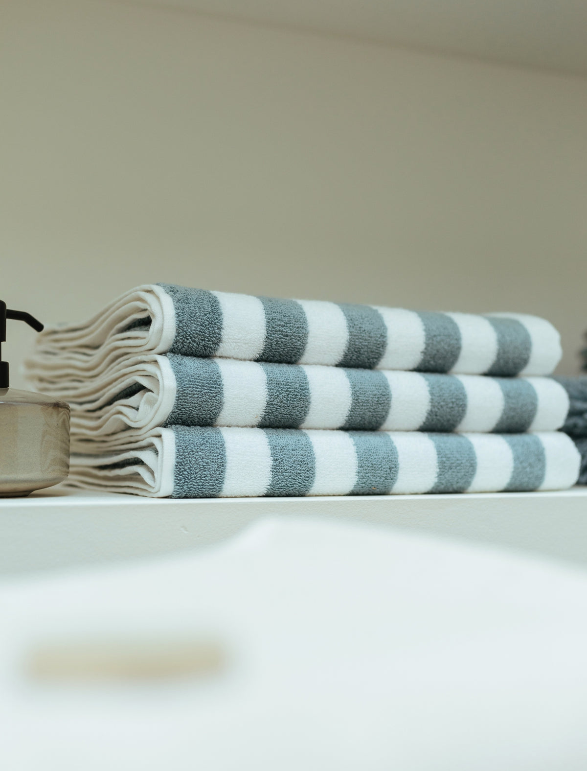 een detail shot van opgevouwen handdoeken met een streep print in wit en blauw