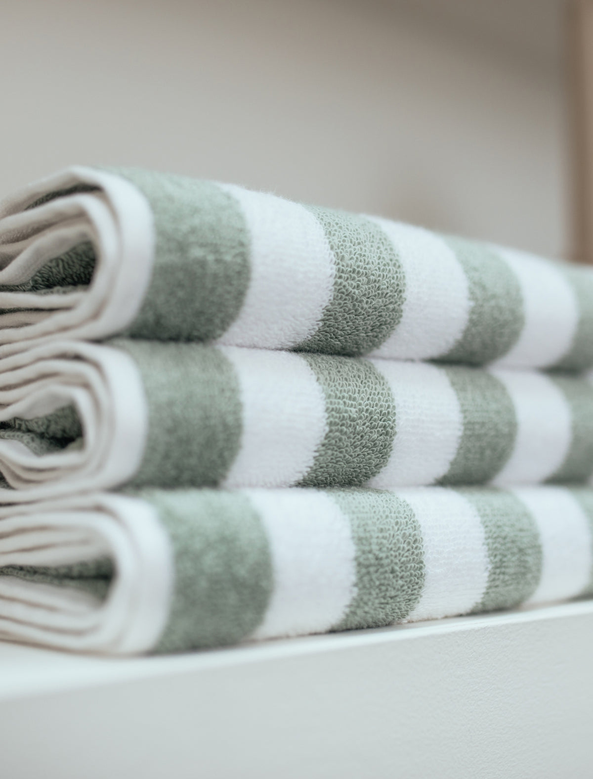 detail shot van handdoeken die op elkaar zijn gestapeld in een streepjes print in witte en groene kleuren