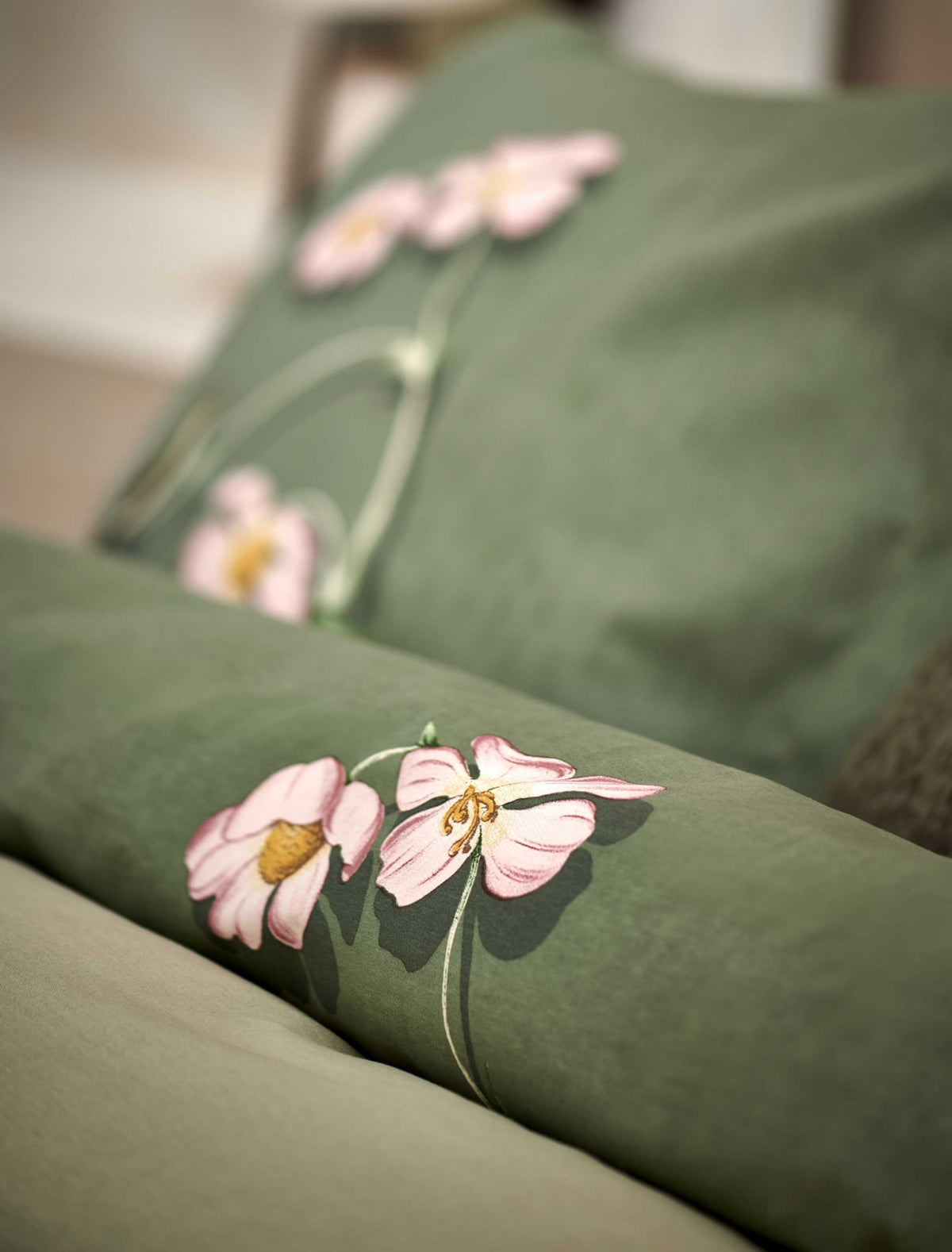 detail shot van een dekbedovertrek in een groene kleur met roze bloemen