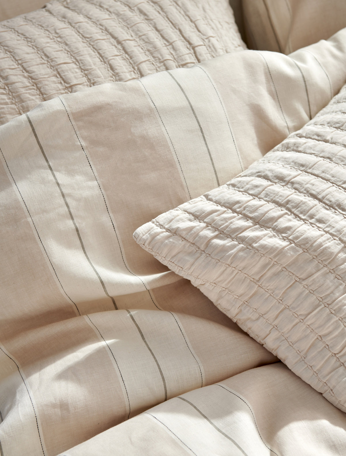 detail shot van een dekbedovertrek in beige tonen met strepen