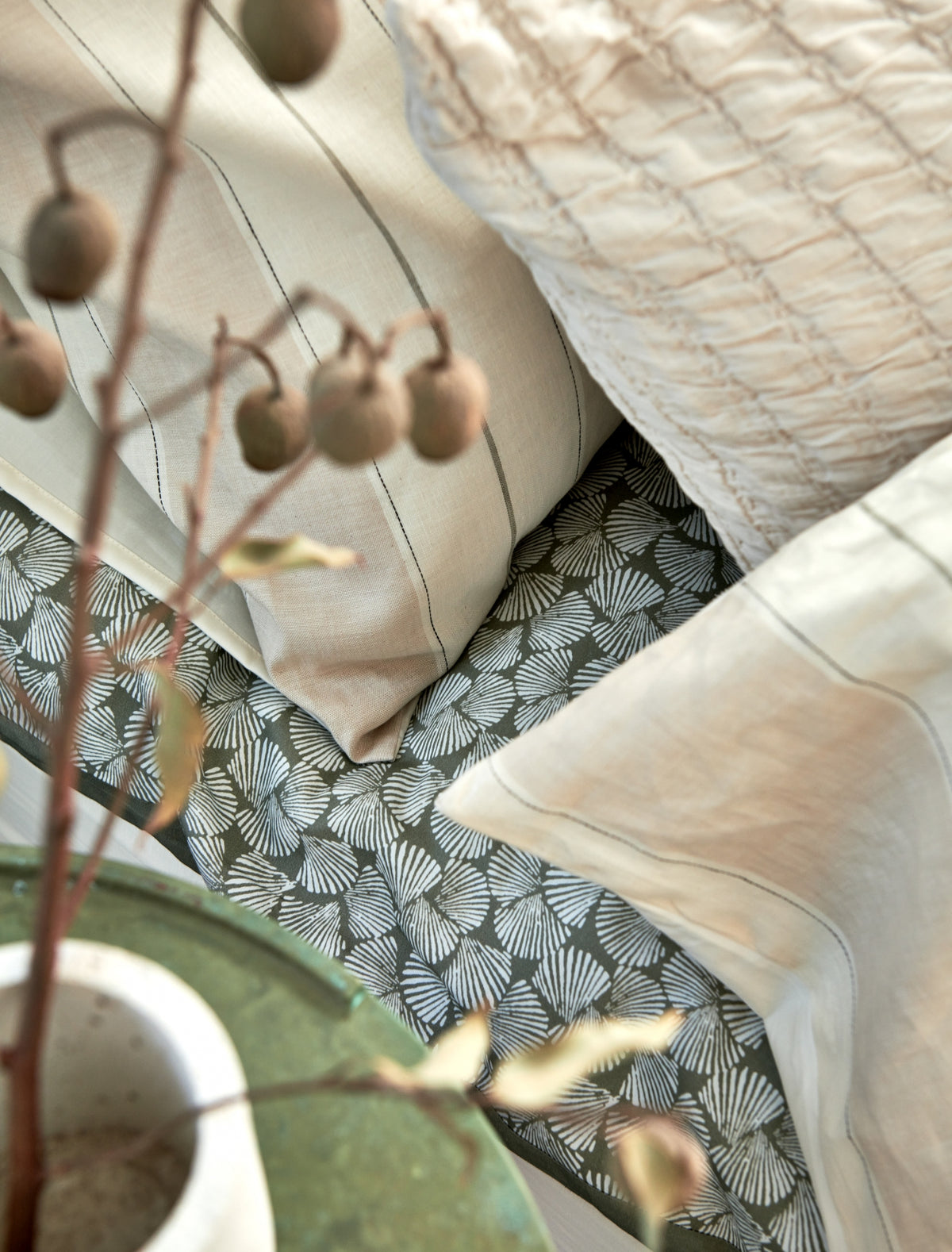 Detail shot van een bed in beige en groene tinten