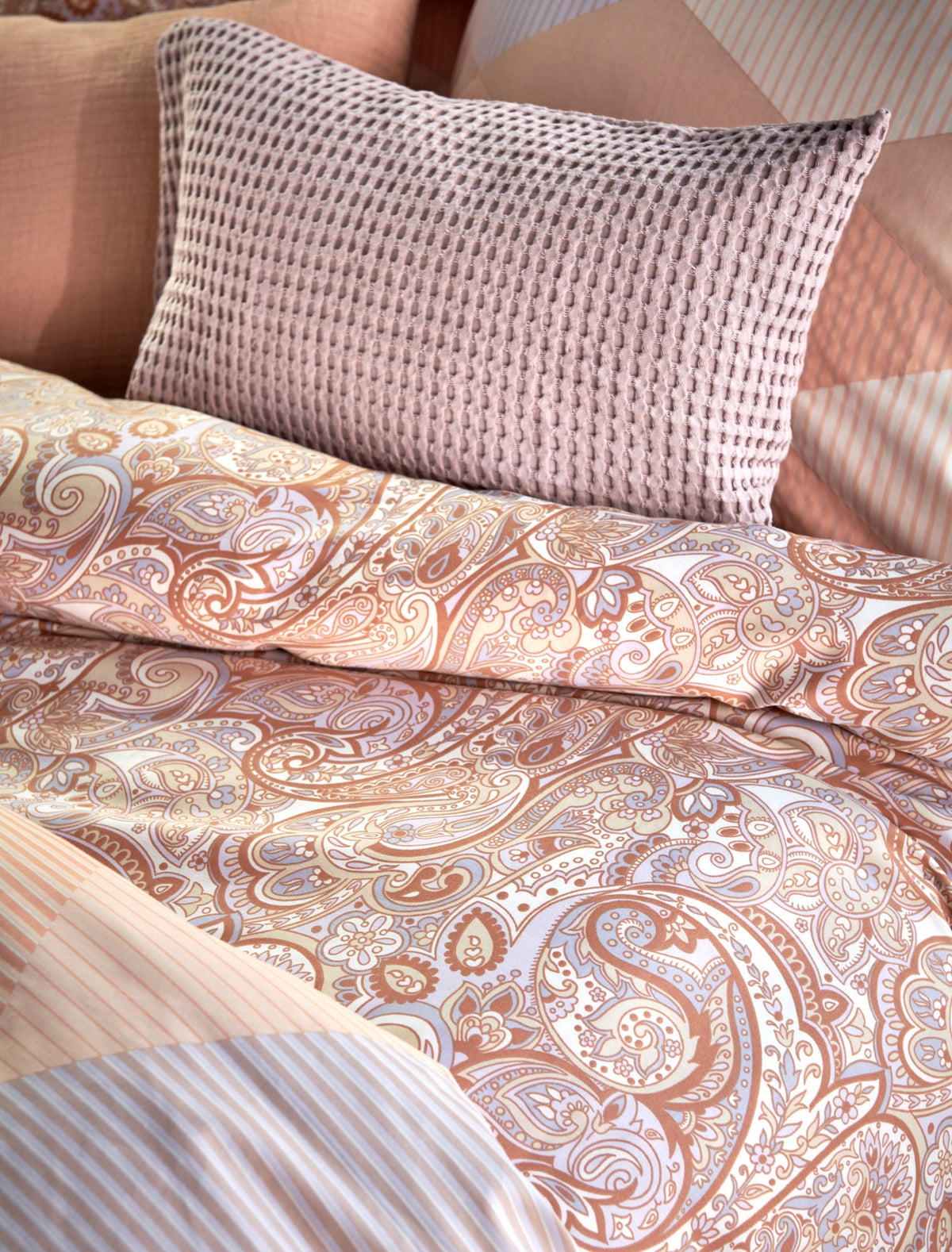 Happy fever apricot blush dekbedovertrek heeft een mooi gedetailleerd paisley patroon in paars en oranje tinten