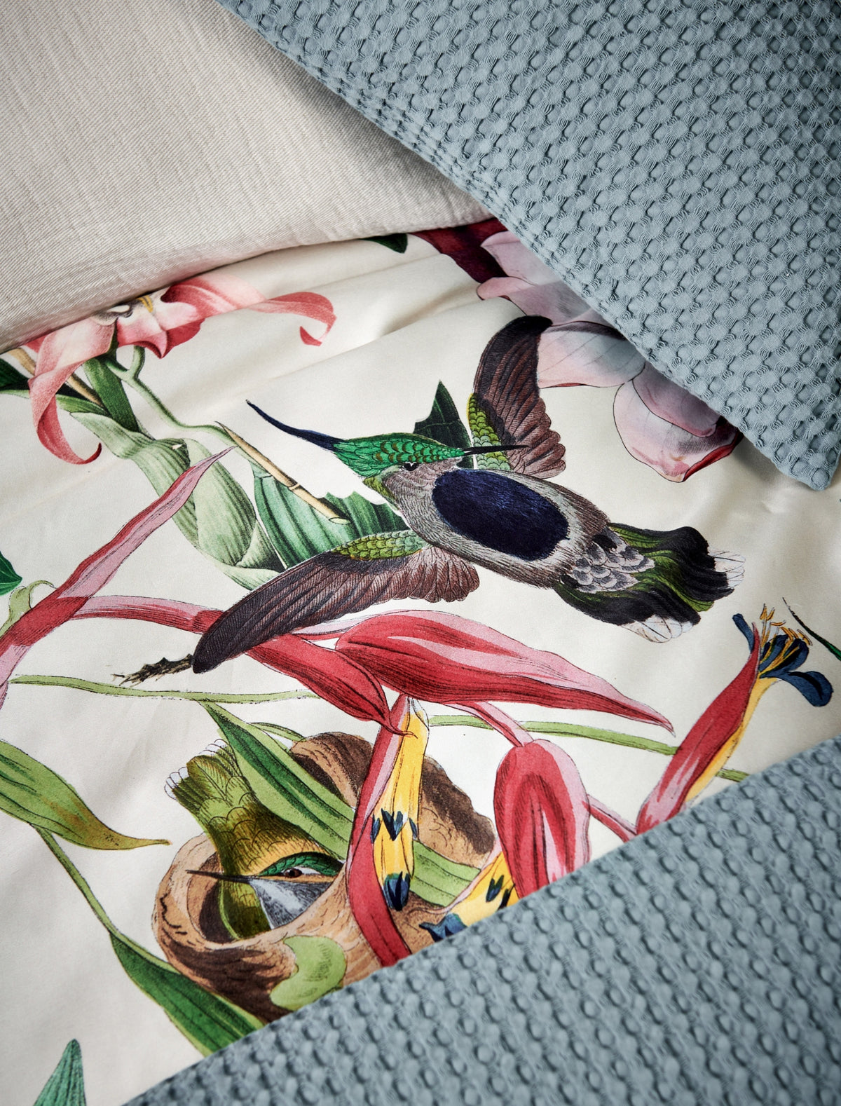 detail shot van een dekbedovertrek met bloemen en vogels met een beige achtergrondkleur