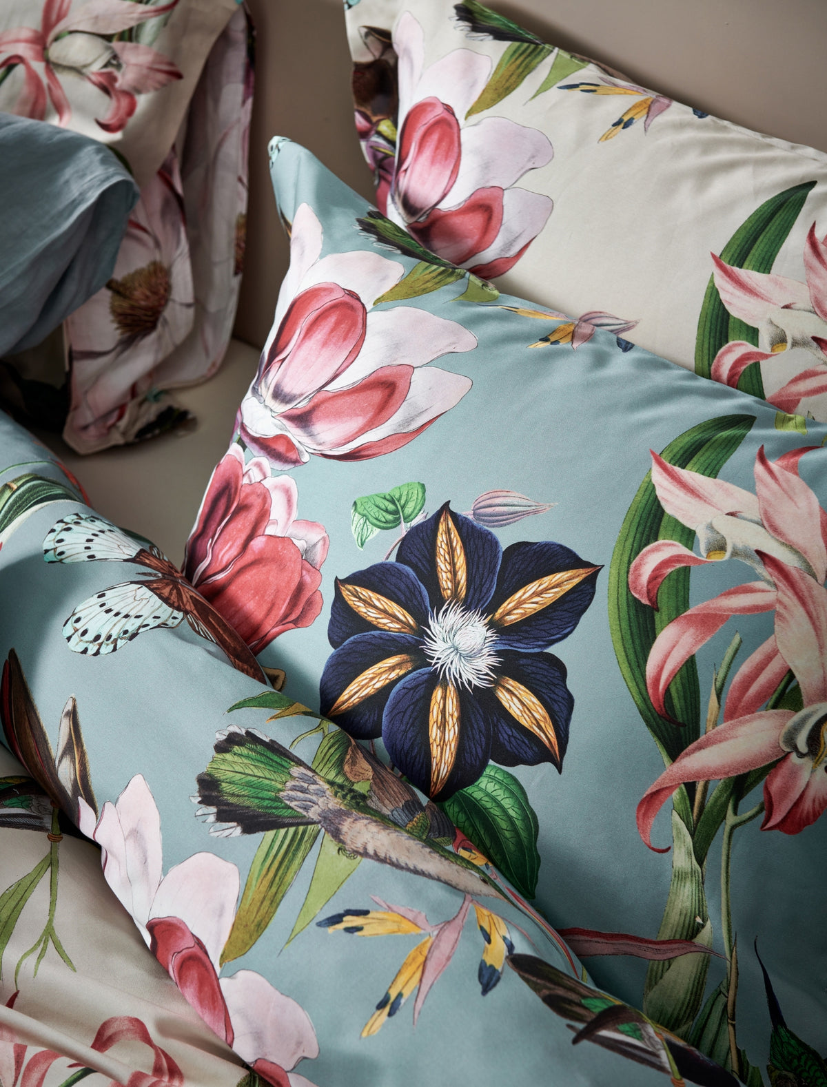 detail shot van een kussensloop in een beige en blauwe kleur met bloemen en vogels