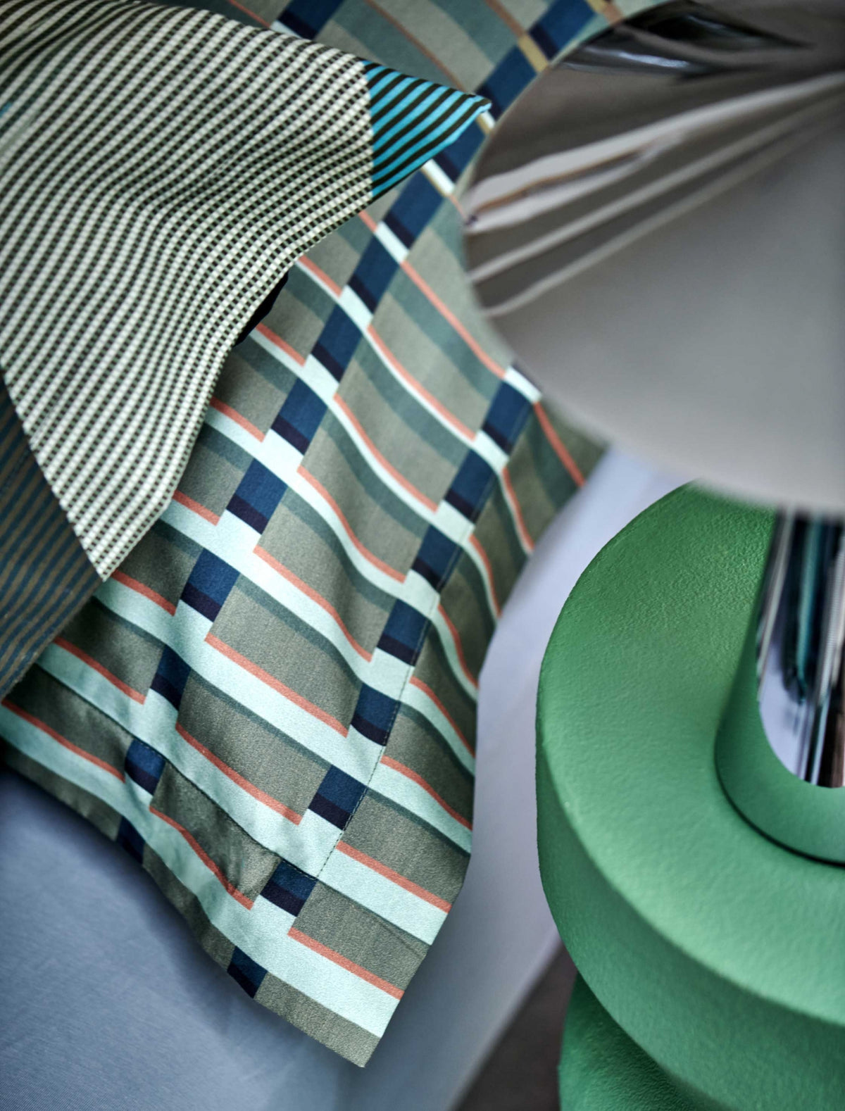 detail shot van een hoofdkussen met strepen in groene en blauwe kleuren
