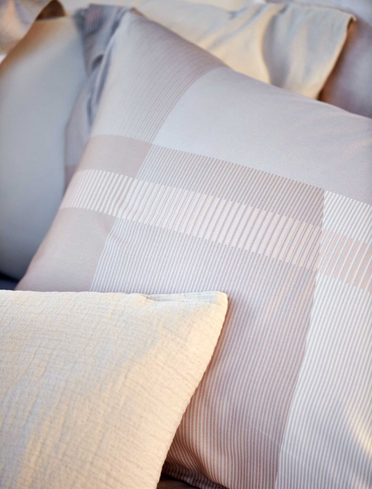 detail shot van een hoofdkussen in beige en lichtblauwe kleuren met een grafische print