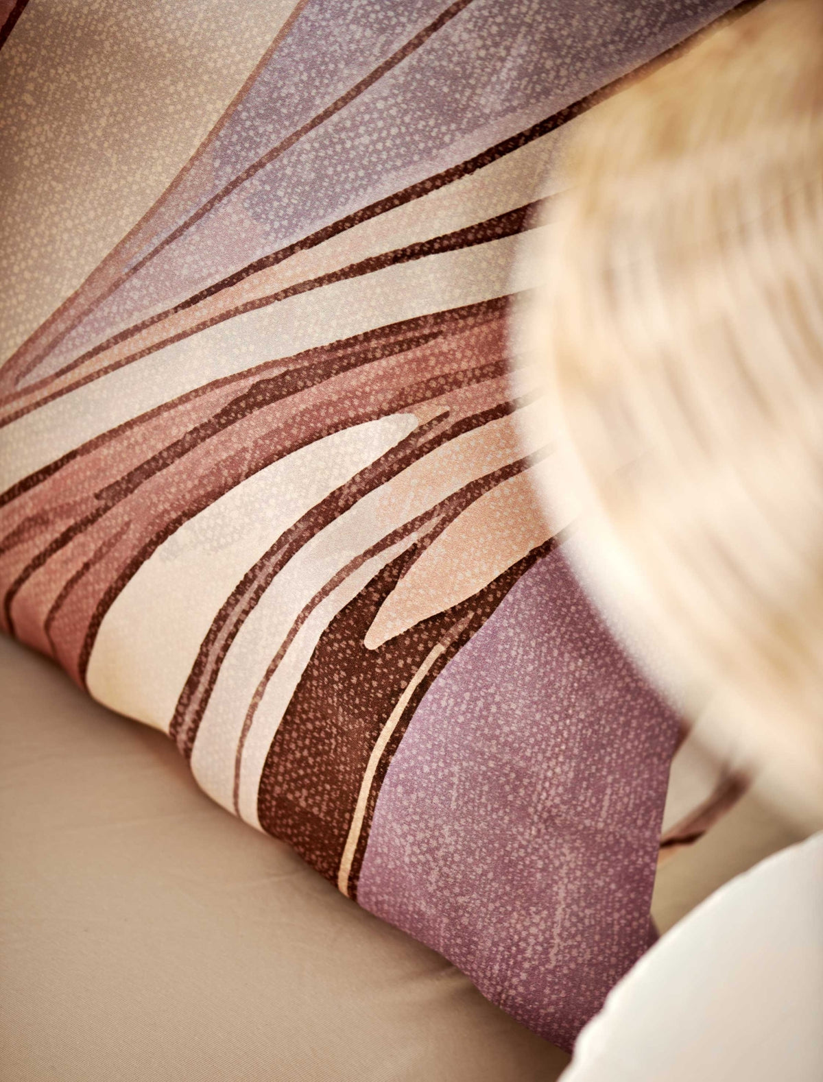 Swirls moonscape dekbedovertrek heeft een abstracte versie van een marmerpatroon met paars, roze en bruine tinten. De achterkant van het dekbedovertrek is effen offwhite. De kussens hebben aan beide zijden hetzelfde patroon. 