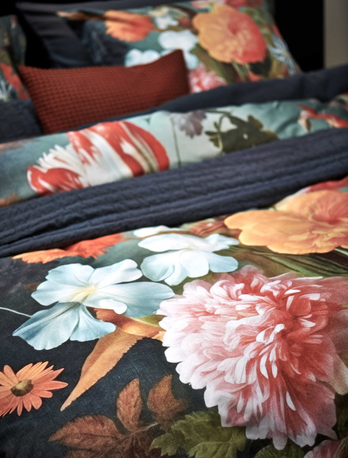 detail shot van een dekbedovertrek met een bloemenprint in blauwe en roze tinten