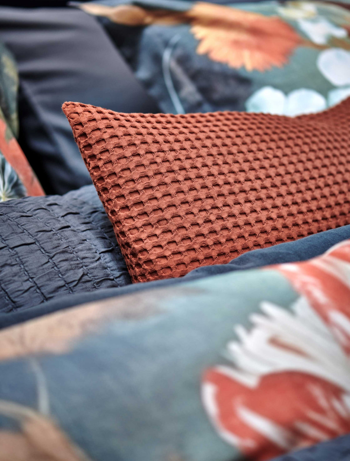 detail shot van een kussensloop in een roest bruine/oranje kleur