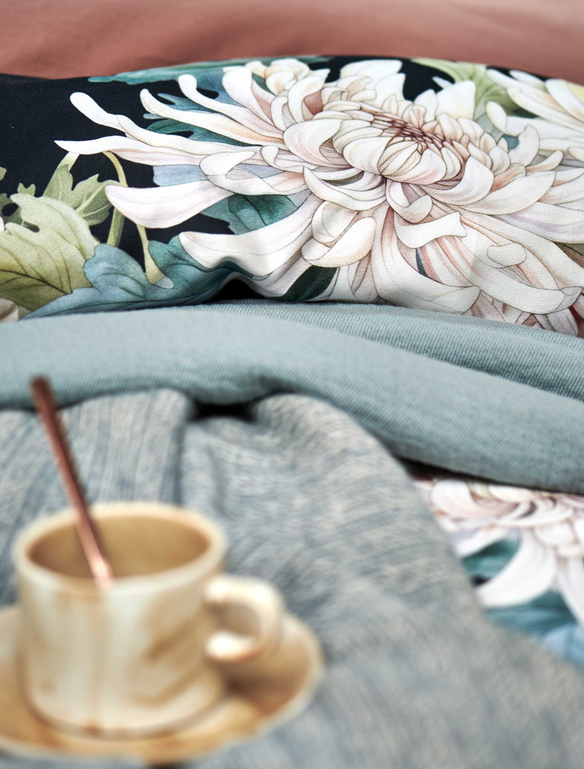 detail shot van een dekbedovertrek in donkerblauw met witte bloemen en een sprei in een blauwe kleur