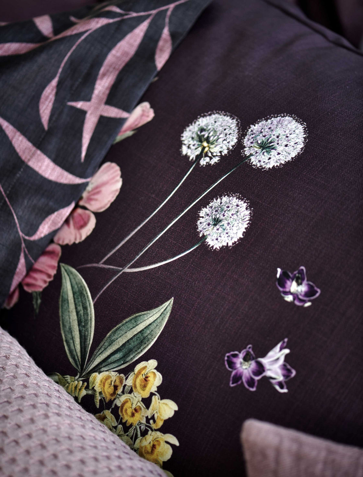 detail shot van een hoofdkussen met bloemen in paarse kleuren
