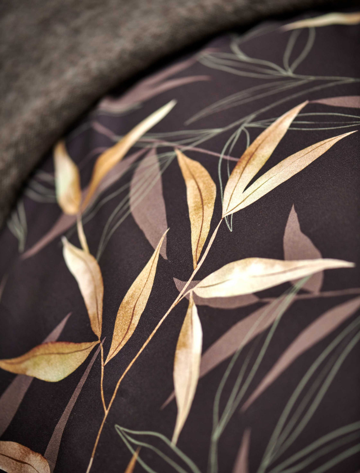 detail shot van een bruin dekbedovertrek met bamboe takken