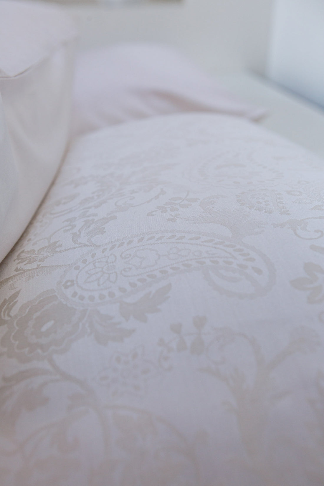 detail shot van een hoofdkussen in het wit met een paisley print